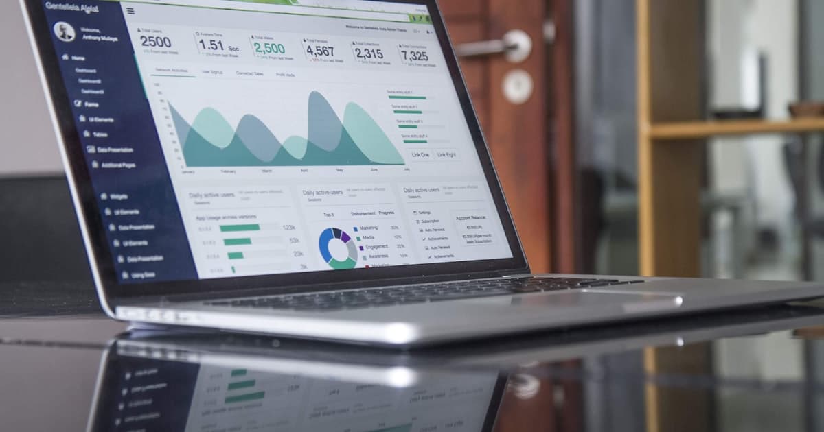 Laptop displaying a business analytics dashboard with user and sales metrics